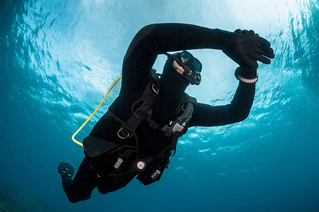 Un plongeur regarde sa montre de plongée dans la baie de Cavalaire